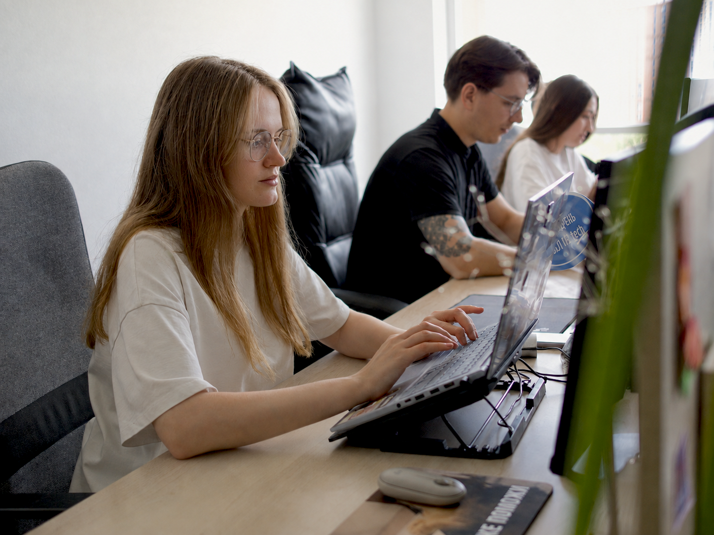 Сотрудники IQ Dev работают за ноутбуками в опен-спейсе