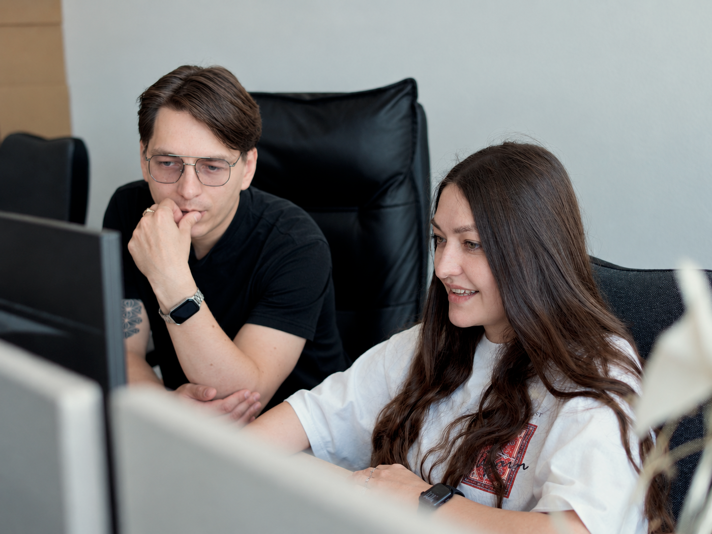 Сотрудники IQ Dev вместе смотрят на экран монитора